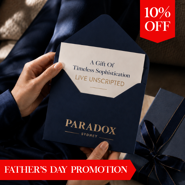 A person holds a navy blue Paradox Sydney gift card or envelope with a white insert card reading 'A Gift of Timeless Sophistication LIVE UNSCRIPTED.' A red '10% OFF' badge appears in the top right, and a red banner at the bottom reads 'FATHER'S DAY PROMOTION.